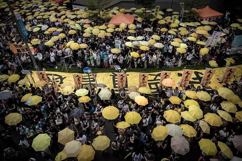 Armed with trademark yellow umbrellas, activists gathered outside Hong Kong's government headquarters yesterday to mark a year since the start of the Occupy movement that tried to force Beijing to liberalise rules on the election of the city's leader