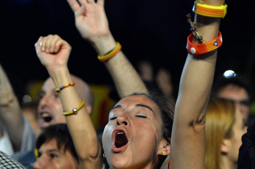 A woman sporting a pro-independence T-shirt chanting slogans following the closing of polling stations during the Catalan regional election on Sunday in Barcelona.