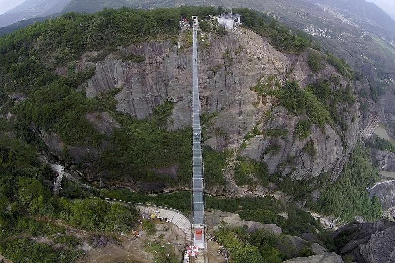 An aerial view of the 300m-long glass suspension bridge (above) at the Shiniuzhai National Geo-park in Hunan province, which opened to tourists (below) for the first time last Thursday.