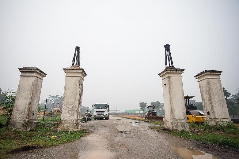 The cast iron gates (above) and four concrete columns (right) at the entrance of Bukit Brown Cemetery are making way for an eight-lane road.