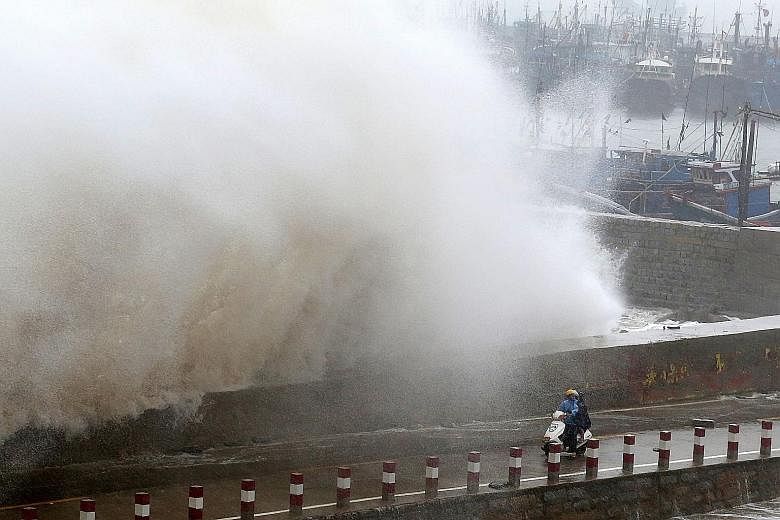 A huge wave crashing over a wall at a pier in Quanzhou city in east China's Fujian province yesterday. Super typhoon Dujuan was forecast to reach Jiangxi province last night.