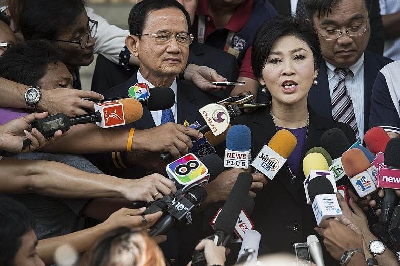 Yingluck Shinawatra, along with her brother-in-law Somchai Wongsawat, speaking to reporters at the court yesterday.