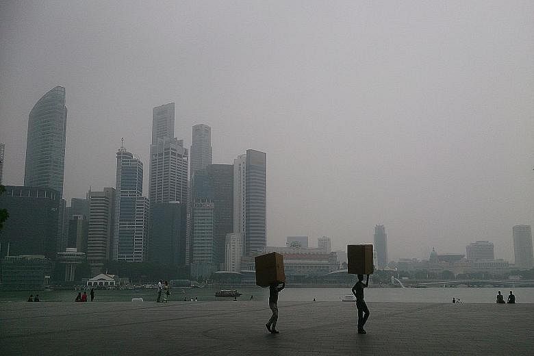 The view of the city skyline from Marina Bay Sands at around 3pm yesterday. The Education Ministry confirmed last night that national exams like the PSLE will proceed as scheduled today. It said schools have made arrangements for candidates to take t