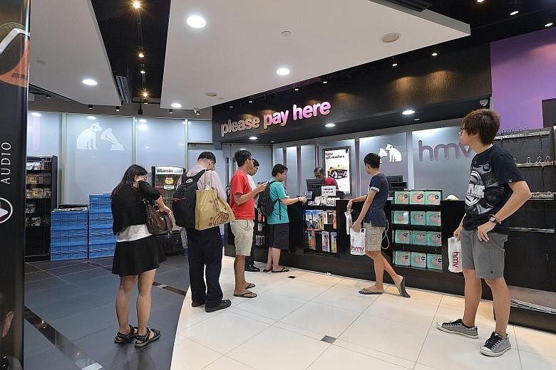 The last few customers queuing to pay for their purchases last night at the HMV store in Marina Square before it closed its doors for good.