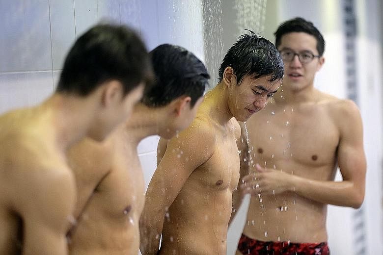 National swimmers Quah Zheng Wen (second from right) and Danny Yeo (right) showering after training at the OCBC Aquatic Centre.