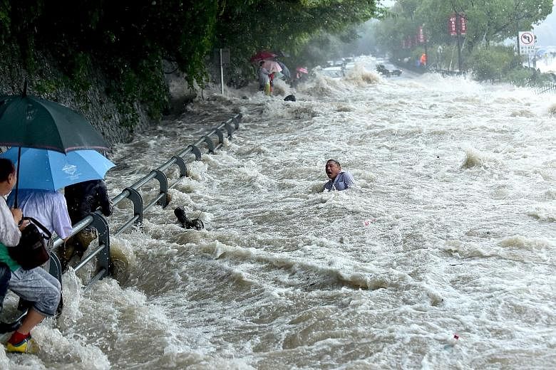 A tourist struggling in the water, before he managed to stand up and wade away, after a wave strengthened by the influence of Typhoon Dujuan hit a river bank in Hangzhou, in eastern China's Zhejiang province, on Tuesday. Spectators watching the tides
