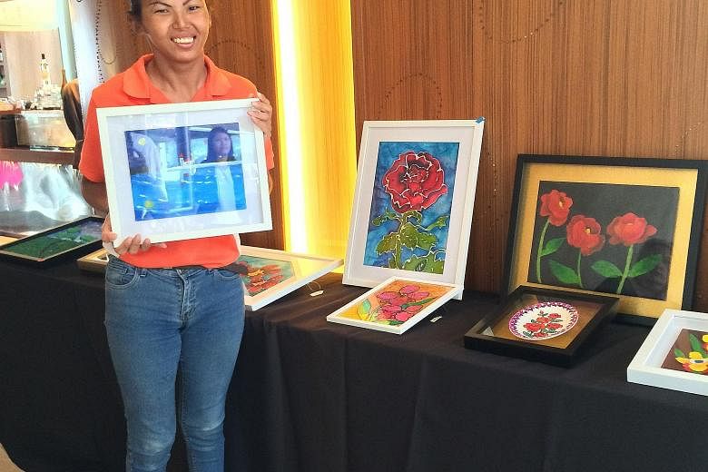 Ms Ng Xiu Zhen, who has cerebral palsy, will have her works displayed alongside those of four others in a travelling exhibition that was unveiled at W Singapore hotel in Sentosa Cove on Sunday. Displayed works at the Art on the Move exhibition are on