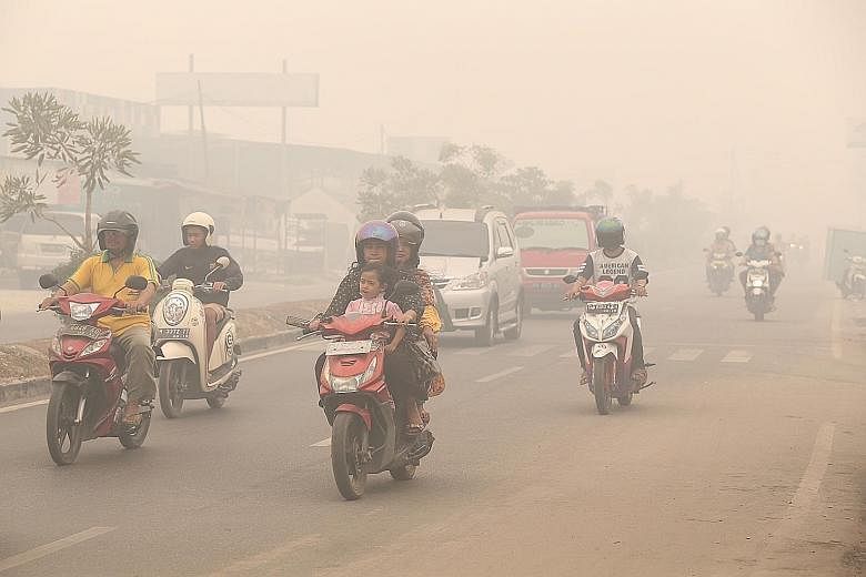 Motorcyclists riding without masks at around noon yesterday in Palangkaraya, Central Kalimantan, where the PSI reached 1,801 in the afternoon and visibility was down to about 100m.