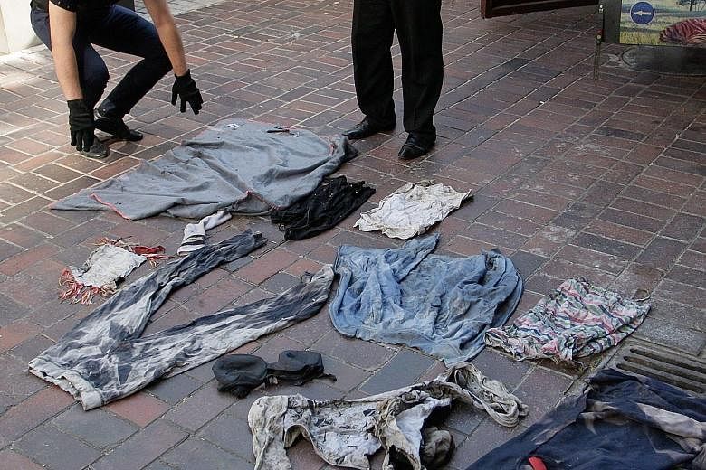 Investigators from the self-proclaimed Donetsk People's Republic inspecting clothes of passengers who died in last year's Malaysia Airlines Flight MH17 crash in Donetsk, Ukraine, on Wednesday. The clothes and pieces of the wreckage will be sent to th