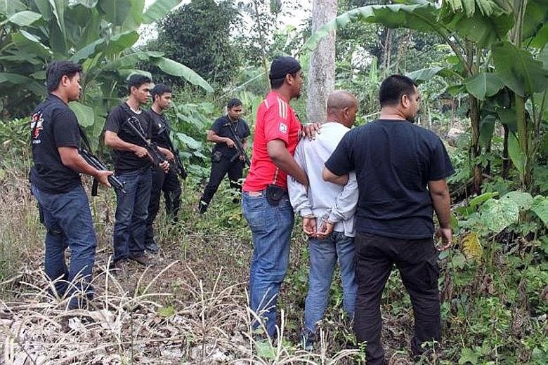 Police detaining a paramilitary member in Perak's Kuala Kangsar town for suspected involvement in a militant group linked to ISIS. There are now some 100 fighters from Malaysia and 500 from Indonesia with ISIS, many of them part of its Malay Archipel