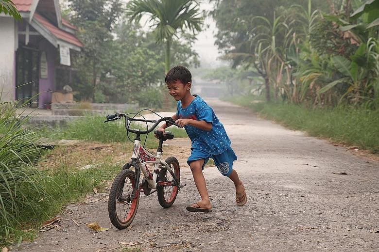 A boy playing on the road despite the air pollution in Palangkaraya, Central Kalimantan, last Thursday.