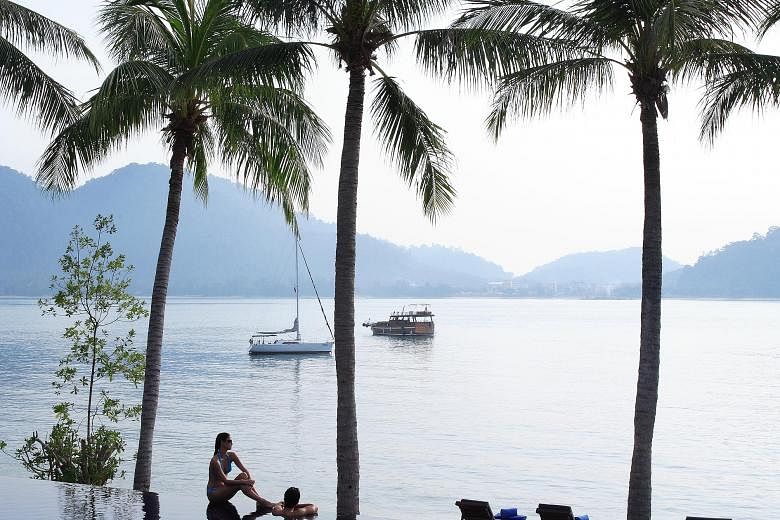 Lounge on a beachchair by the sea (left) or enjoy the sea breeze from the villa (above). Pangkor Laut Resort is set on a private island filled with lush rainforests.