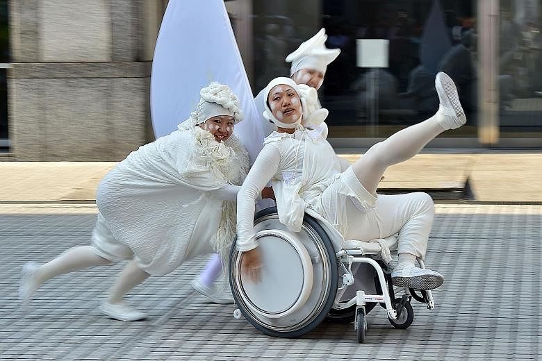 Dancers performing on a prototype of an electric wheelchair, dubbed the &Y01 or Andy 01, at a Slow Movement event in Tokyo. Japan's musical instruments conglomerate Yamaha and motorcycle giant Yamaha Motor produced the wheelchair, which plays music f