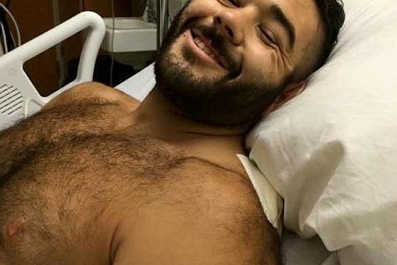 Mr Chris Mintz, who was shot seven times while trying to stop the gunman, recovering in hospital.