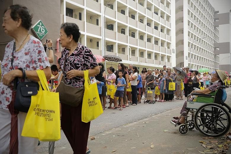 People queuing for ice-cream yesterday at the farewell carnival giving former residents of Blocks 74 to 80, Commonwealth Drive, a chance to say goodbye to their former estate. The blocks will be demolished next month for redevelopment.