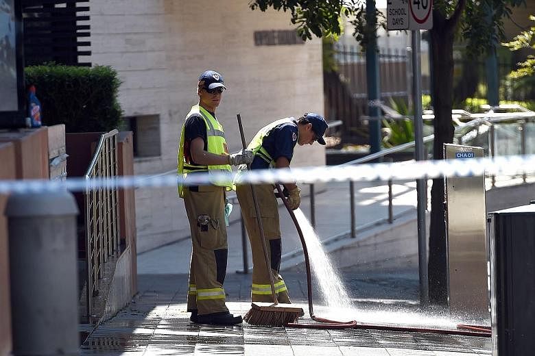 Firemen on Saturday hosing down the scene where a 15-year-old gunman had shot dead a civilian police employee the previous day before being gunned down by police in Sydney.