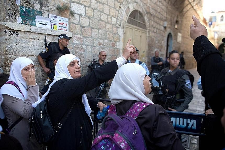 Palestinian women shouting slogans during a demonstration in the Muslim quarter of Jerusalem's Old City yesterday.