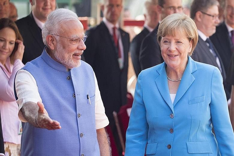 Indian Prime Minister Narendra Modi greeting German Chancellor Angela Merkel upon her arrival in New Delhi yesterday.