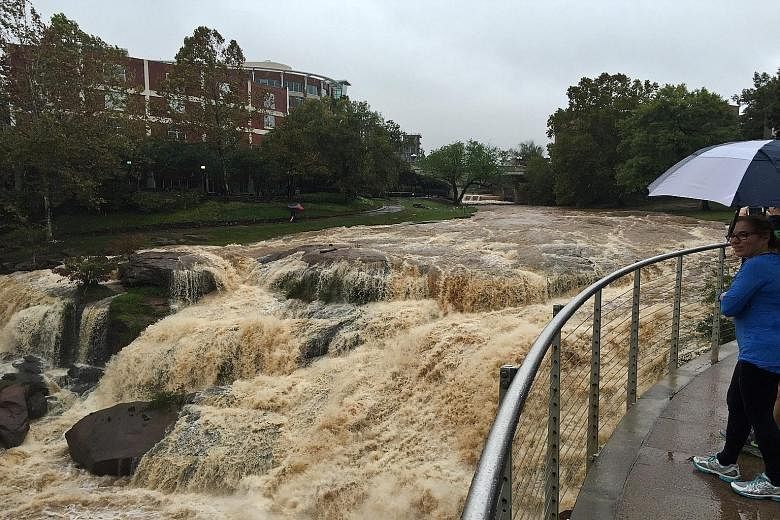 Flood waters in downtown Greenville, South Carolina, after record rainfall which left large areas submerged. At least eight people have died since the wild weather hit the Carolinas last Thursday. US President Barack Obama has declared a state of eme