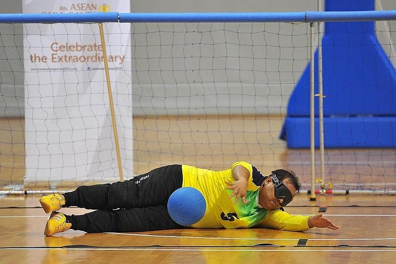 Above: Nazarudin, 37, goalball athlete, making a save. Left: Kamas Mohd and Chua Chong Hoi tussling in a wheelchair basketball demonstration event.