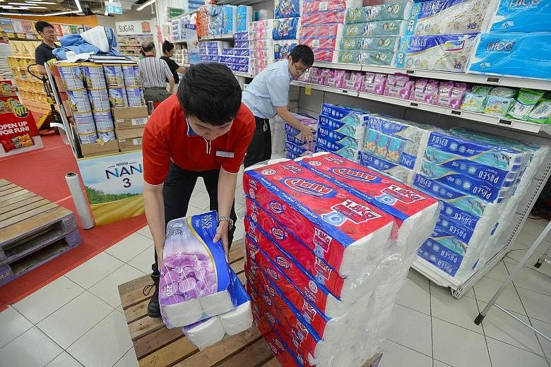 Staff removing APP-related products from shelves at FairPrice's outlet at Nex mall in Serangoon yesterday. Late last month, the National Environment Agency began legal action against APP and four Indonesian firms it believes to be behind the haze-cau