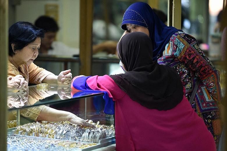 A gold jewellery vendor attending to customers in Jakarta. A softer US dollar helped lift gold to a seven-week high of US$1,148.65 an ounce, a spike of 3.8 per cent from $1,107.03 last Friday, and is up nearly 1 per cent from Tuesday.
