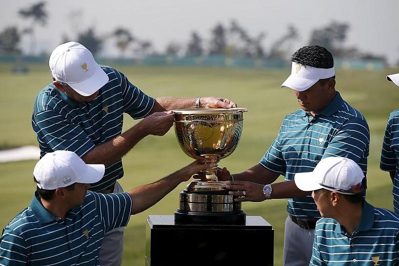 Clockwise from top left: International team captain Nick Price, K.J. Choi, Bae Sang Moon and Jason Daygather round the Presidents Cup as they get ready to pose for a group photo before the 2015 edition begins in Incheon today. The United States have 