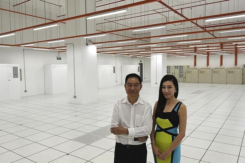 Mr Sok Hang Chaw, Kingsland Development founder and chairman, and the company's executive director Shann Sok Aixuan at the Jurong data centre. Security features include a man-trap with biometric palm reader (below) and many closed-circuit TV cameras.