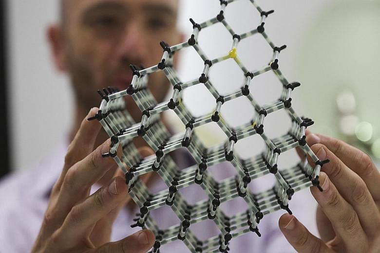 An employee holding up the molecular structure model of a diamond in the De Beers Element Six laboratory in Didcot, Britain. About 360,000 carats of man-made gems were produced last year, compared with 126 million carats of natural diamonds. Because 