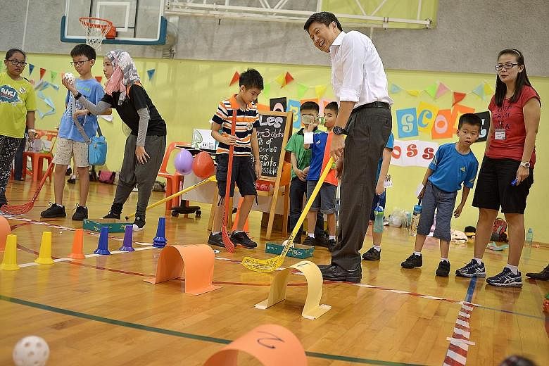 Acting Minister for Education Ng Chee Meng trying out Score! Score!, a game organised by pupils from Frontier Primary's Red Cross CCA, at the school's Children's Day carnival yesterday.