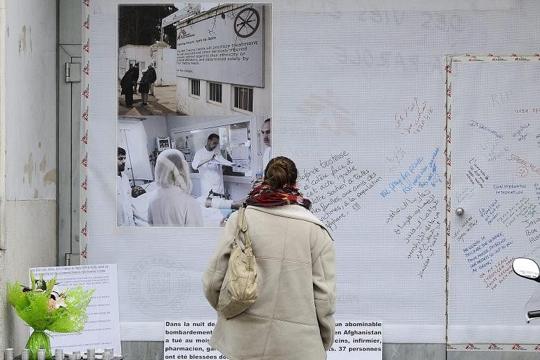A woman reading messages left outside the headquarters of Doctors Without Borders in Geneva, Switzerland, on Wednesday in the wake of the US bombing of the group's field hospital in the Afghan city of Kunduz last Saturday.