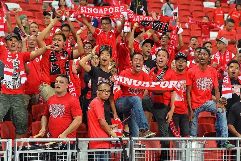 Above: Khairul Amri scoring the lone goal with a header from a corner kick. Left: Singapore's fans celebrate in a relatively empty stadium, with only 7,128 turning up. Right: Amri with the trophy awarded for joining the century club in terms of inter