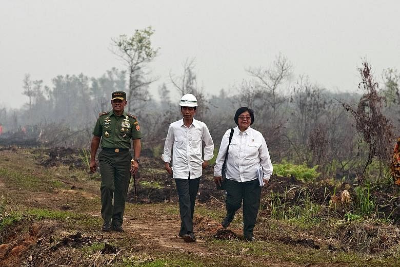 Indonesian President Joko Widodo (centre) with TNI chief Gatot Nurmantyo (far left) and Environment and Forestry Minister Siti Nurbaya yesterday as they reviewed the handling of forest fires at the Long Rimbo village in Kampar regency, Riau province.