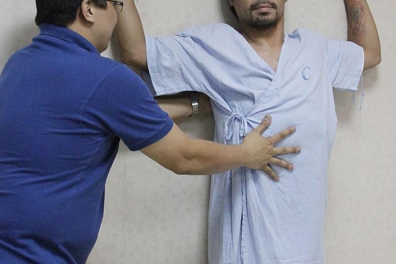 Manny Pacquiao being coached by a Philippine doctor to do some exercise two weeks ago to rehabilitate his right shoulder rotator cuff, which he injured while training for May's mega-bout with the American Floyd Mayweather. The boxer intends to have o