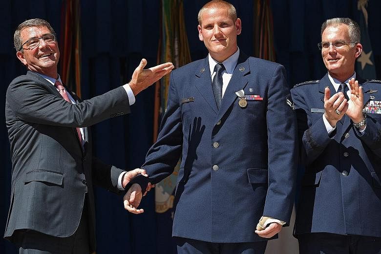 Mr Spencer Stone being congratulated on his heroic act by US Defence Secretary Ashton Carter (left) and vice-chairman of the Joint Chiefs of Staff, General Paul Selva, at an awards ceremony at the Pentagon last month.