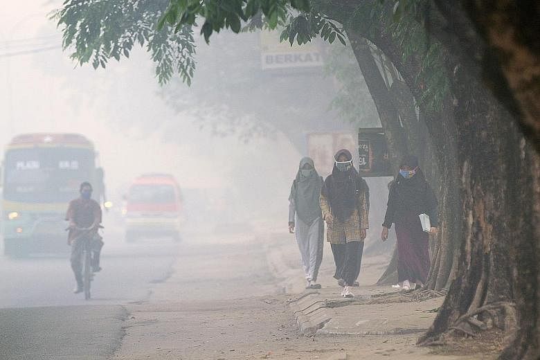 Pedestrians wearing face masks to protect themselves from air pollution in Palembang, Indonesia, earlier this week.