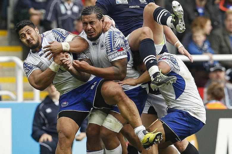Samoa's Alafoti Fa'osiliva (far left) shielding the ball from Scotland during their Rugby World Cup clash in Newcastle yesterday. Scotland won 36-33 to advance to the quarter-finals as Pool B runners-up, at the same time eliminating Japan even though