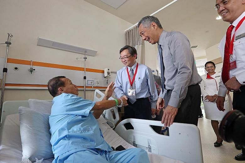 Prime Minister Lee Hsien Loong and Health Minister Gan Kim Yong visited patients, including Mr Chionh Koek, 62 (above), at the Ng Teng Fong General Hospital yesterday. Mr Lee spent about two hours touring the hospital and the adjoining 400-bed Jurong