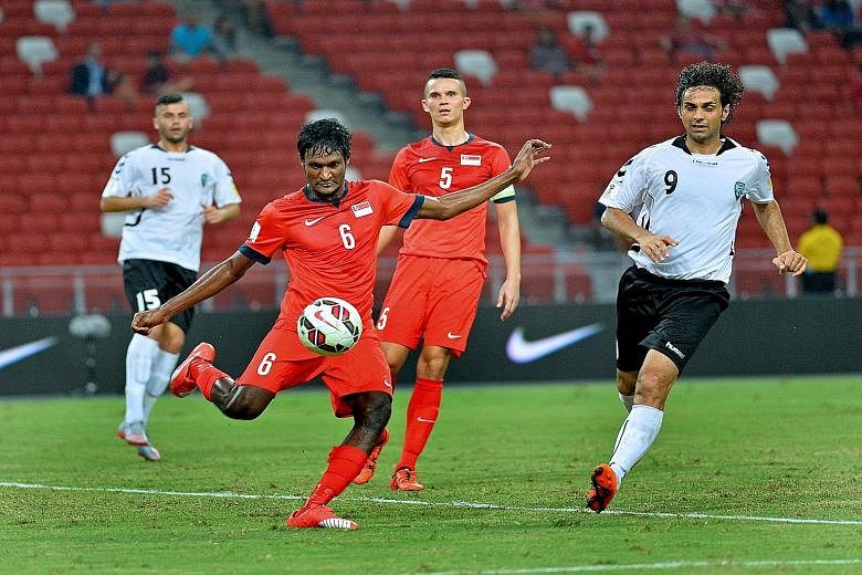 Madhu Mohana clears the ball while Baihakki Khaizan keeps a close watch as the central defenders help Singapore earn a crucial 1-0 win over Afghanistan in a Group E World Cup qualifier.