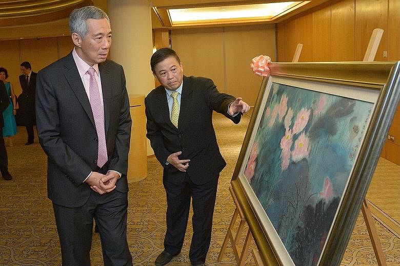 Guest of honour, Prime Minister Lee Hsien Loong, with Sin Hua Gallery owner Chan Kok Hua, who donated the painting Glorious Lotuses, by Beijing artist Liu Yanshui, for the Singapore Chinese Orchestra's fund-raiser on Friday night.