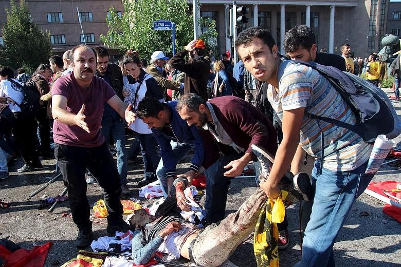 After the double explosions outside Ankara's main train station, bodies covered by flags and banners, including those of the pro-Kurdish opposition Peoples' Democratic Party (HDP), lay scattered on the road among bloodstains and body parts.