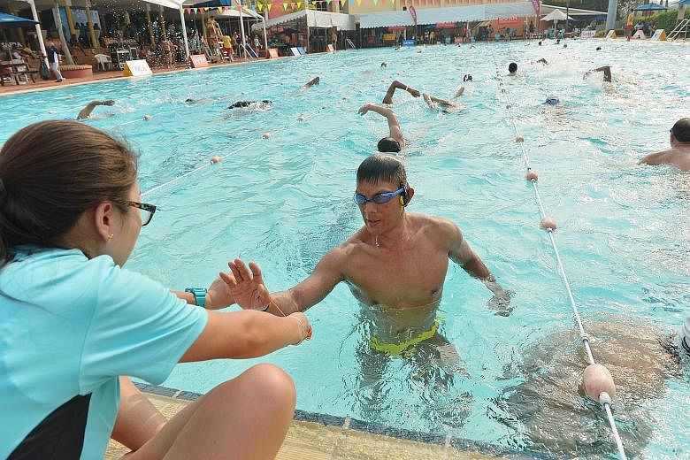 Mr Vincent Koh getting a rubber band from an official to help him keep track of the number of laps swum in the three-day Swim for Hope event yesterday. A total of 1,700 swimmers raised $79,038 for four beneficiaries: Aquatics Heart and Hope, Communit