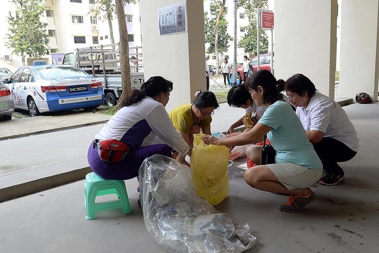 Residents learning how to sort their recyclables and reject items that cannot be recycled at the new recycling point at Block 868, Yishun Street 81. Teaching sessions will be held there once a month.