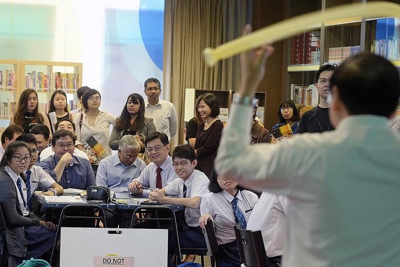 Former Education Minister Heng Swee Keat (with red tie) with students at a physics class during a school tour last month. Many educators have praised his contributions to the sector.