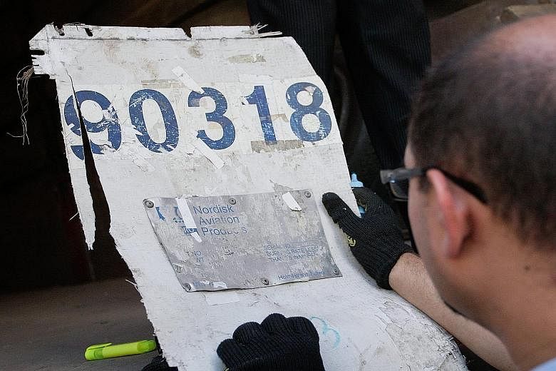 An investigator inspecting a piece of wreckage from the Malaysia Airlines Boeing 777 plane, during preparations to send it to the International MH17 Commissionlast month.