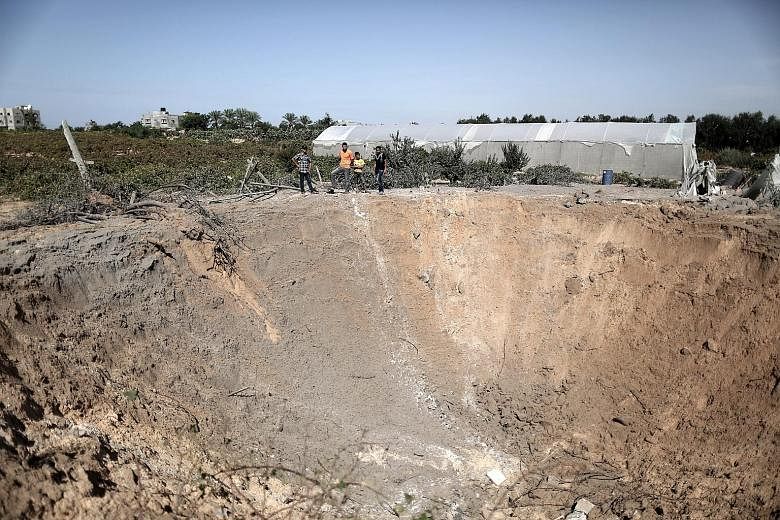 A crater created by an Israeli air strike in the Gaza Strip yesterday. The Israeli military said it had targeted two Hamas weapon sites.