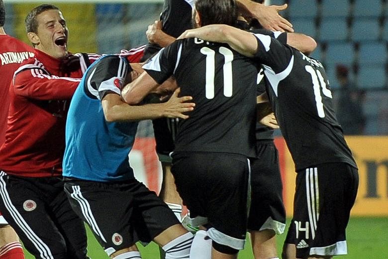 Albania's players celebrating their qualification for next year's European Championship after defeating Armenia 3-0 in Yerevan on Sunday. It is the first time the country, with a population of just 2.77 million, has reached a major football tournamen