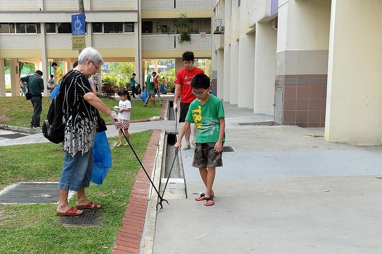 Residents taking part in a litter-picking exercise in Yishun Street 81 on Sunday. Ms Lee Bee Wah yesterday said she suggested the reward system idea to the NEA a few months ago and hoped to roll out a pilot in Nee Soon South.