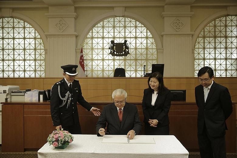President Tony Tan Keng Yam signing a guestbook after his tour of the State Courts and Family Justice Courts yesterday. It was his first visit to both courts. "With the formation of these two institutions, our judicial system has become more effectiv