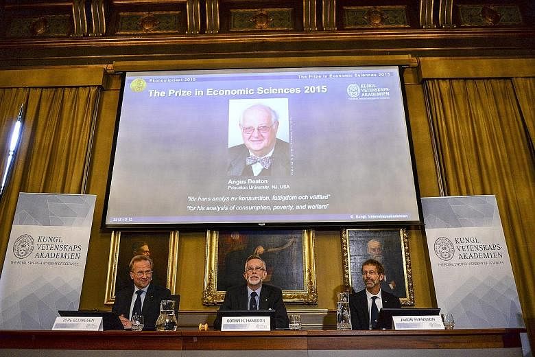 A picture of Professor Angus Deaton, this year's recipient of the Nobel Prize in economics, is seen on a screen as (from left) Mr Tore Ellingsen, chairman of the prize committee; Mr Goran Hansson, permanent secretary for the Royal Swedish Academy of 